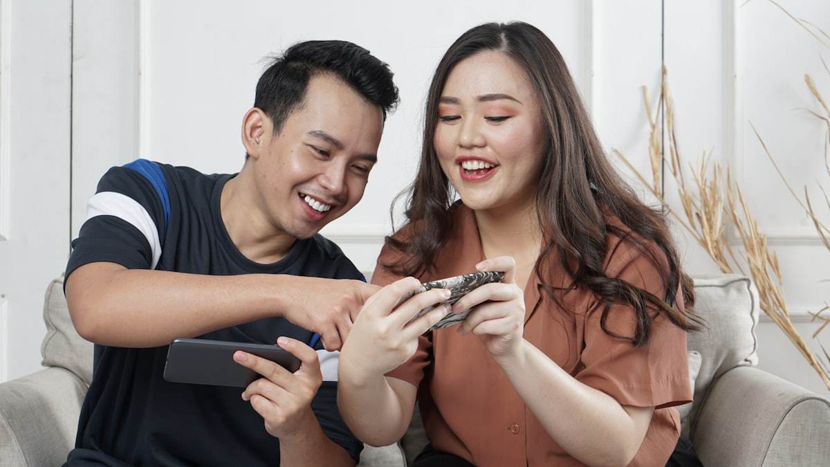 Seseorang bersantai memegang ponsel di sofa
